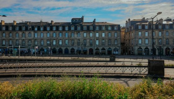 Bâtiments historiques élégants à Bordeaux, France sous un ciel bleu clair.